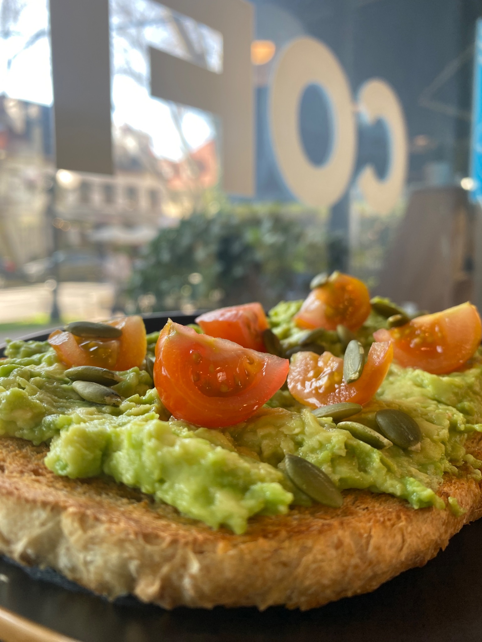 Tostada con palta y tomate servida en COFI